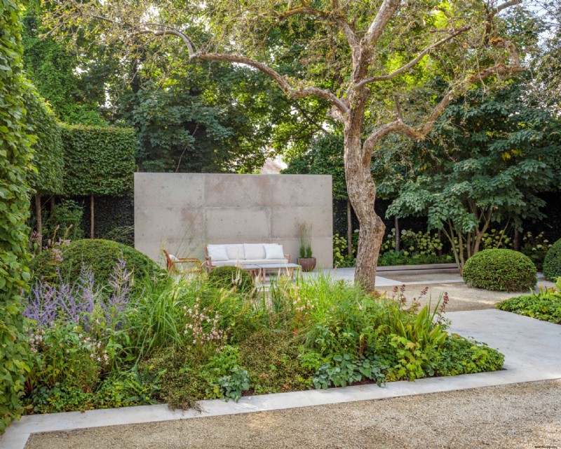 Ein minimalistischer Stadtgarten mit Außenräumen und modernem Formschnitt 